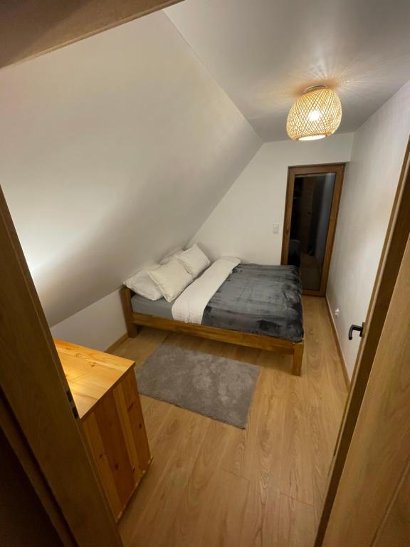a small bedroom with a bed in a attic at Lasóweczka in Lasowka