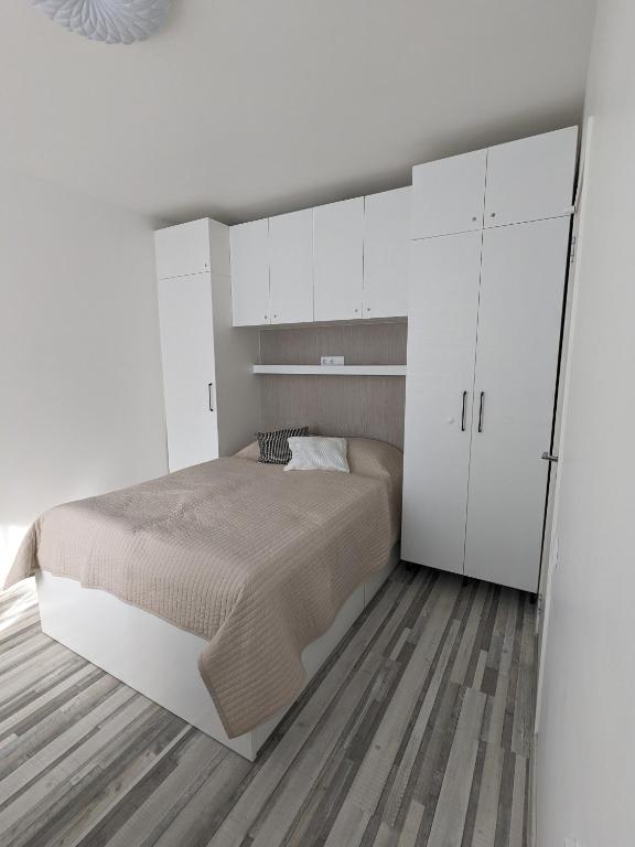 ein weißes Schlafzimmer mit einem Bett und weißen Schränken in der Unterkunft Sea Of Nida 2 in Nida