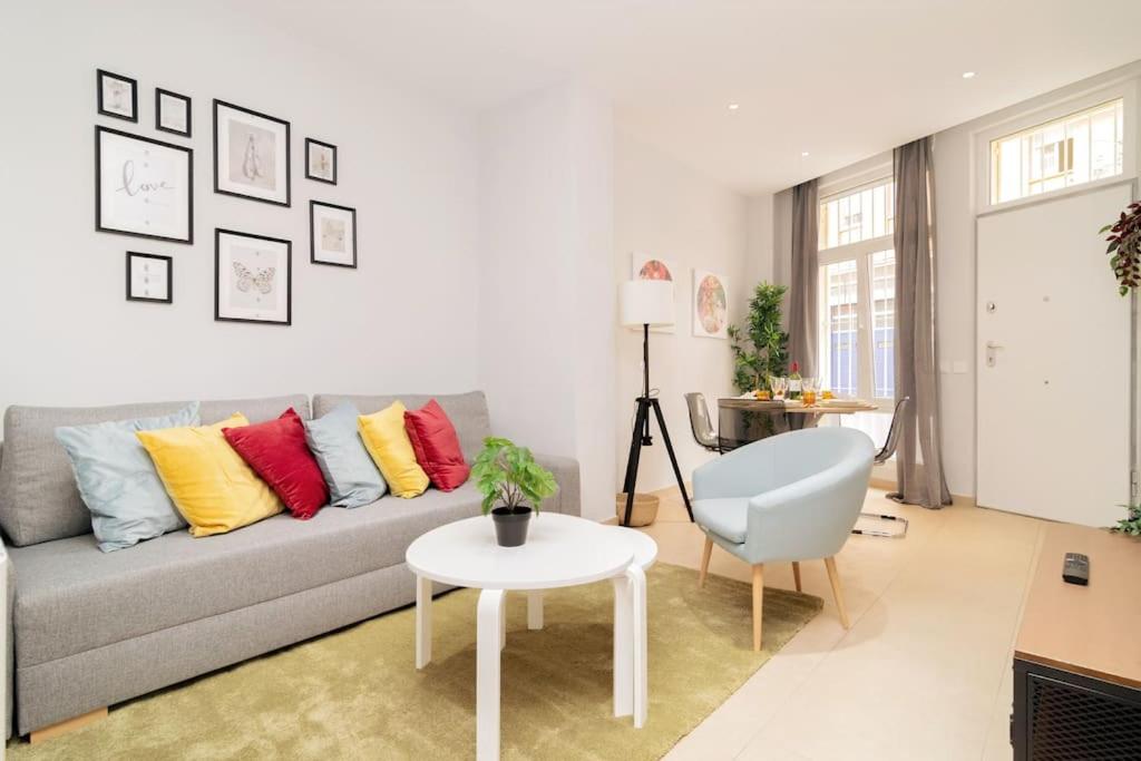 sala de estar con sofá gris y almohadas coloridas en Encanto Celestial en Santa Úrsula en Madrid