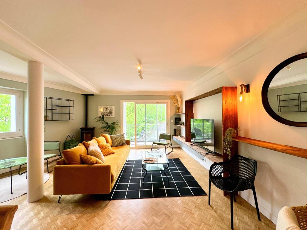 salon z żółtą kanapą i lustrem w obiekcie Bel appartement 100 m2 / Parking / Paisible w mieście Rodez