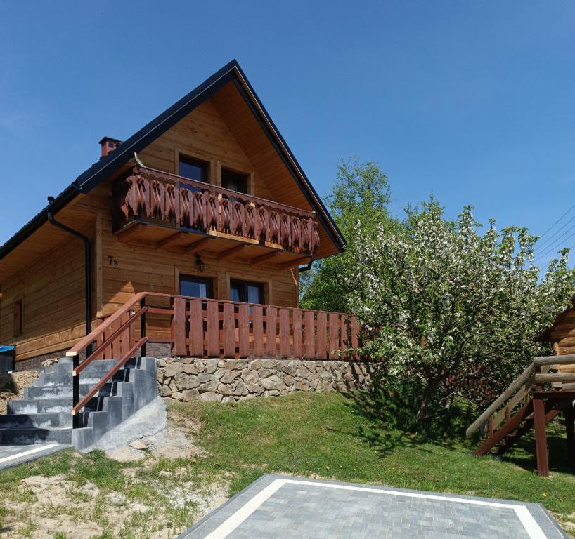 uma cabana de madeira com uma escada que leva a uma casa em Domek w Pieninach em Grywałd