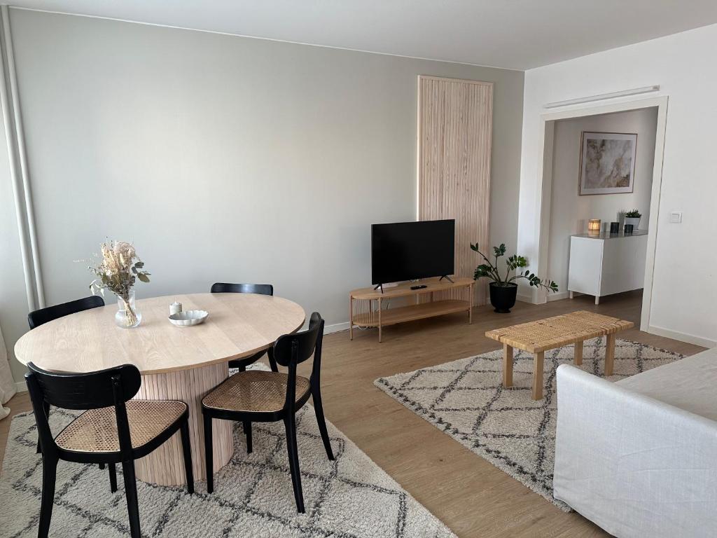 a living room with a table and chairs and a tv at Arctic City Apartment in Rovaniemi