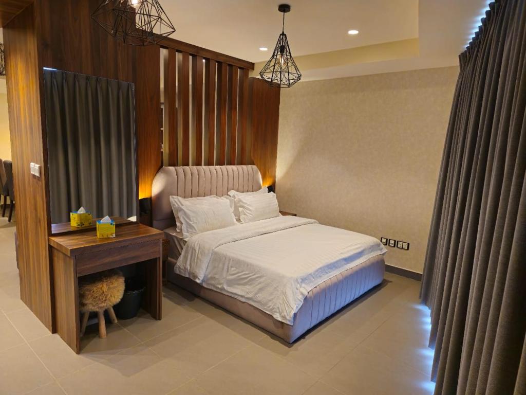 sypialnia z łóżkiem i biurkiem oraz łóżko o wymiarach 6 x 6 x 6 w obiekcie Luxury Apartments - Damac Tower Amman w mieście Amman