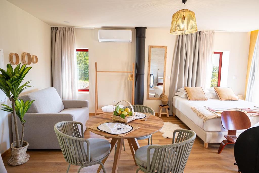uma sala de estar com uma cama, uma mesa e cadeiras em Peso Village em Amarante