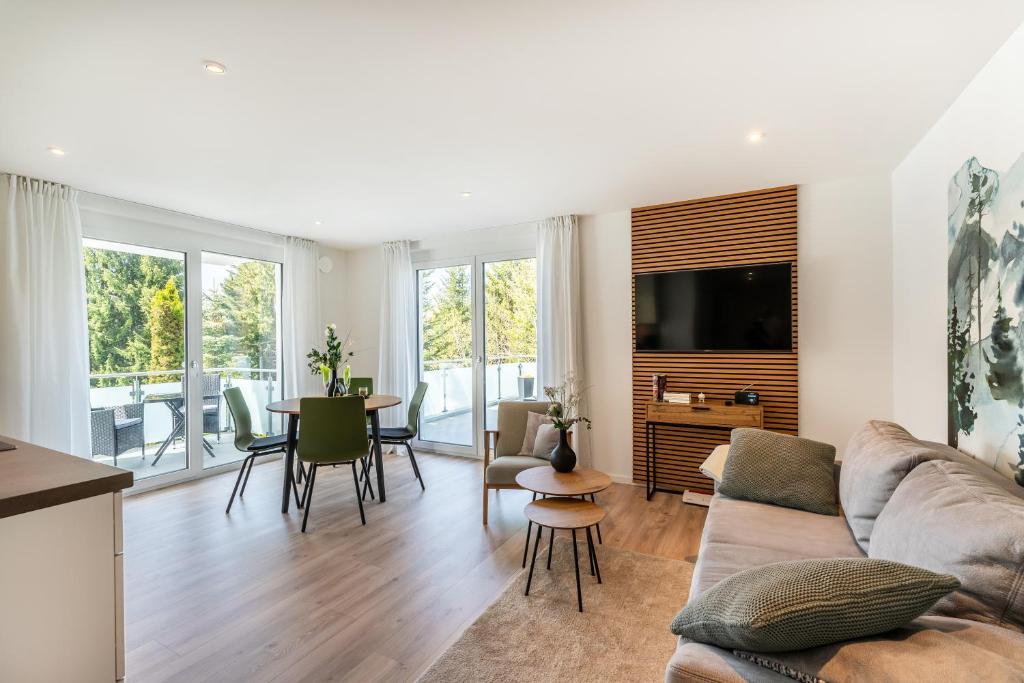 a living room with a couch and a table at Luxuswohnung Traumblick - Neubau 2023 in Schluchsee