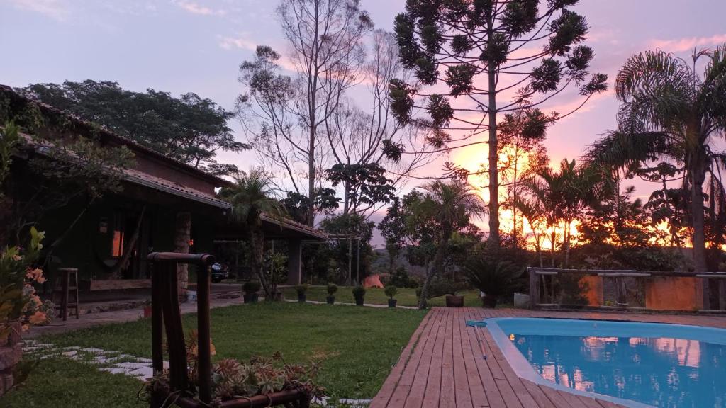 ein Haus mit Pool und Sonnenuntergang in der Unterkunft Chácara Tavares em São Roque in Taxaquara
