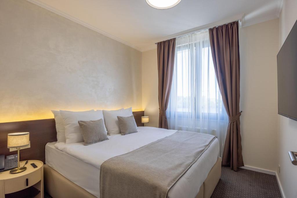 a hotel room with a bed and a window at Nobel West Hotel in Belgrade
