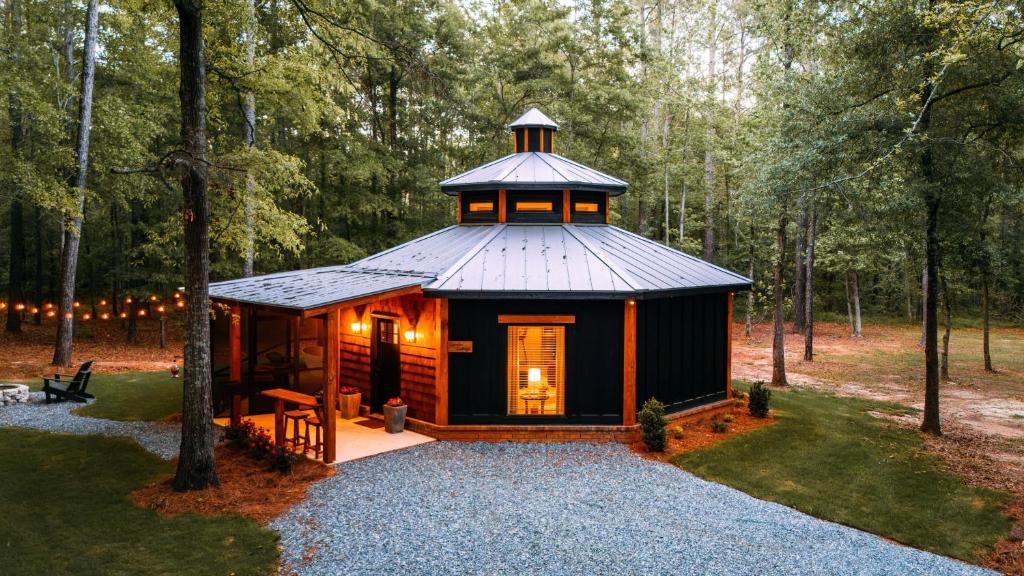 a cabin in the woods with a tower on top at Romantic Gazebo Cottage w Hot Tub & Pond in Marshallville