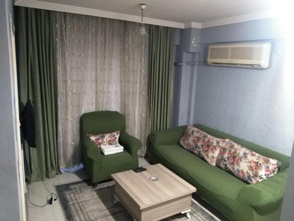 een woonkamer met een groene bank en een stoel bij Egepar Rezidance Apart in Buca