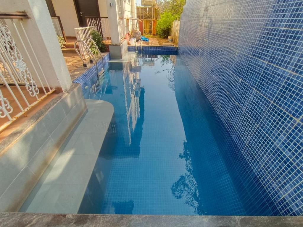 una piscina con acqua blu in una casa di Marine Studios by Le Pension Stays a Marmagao