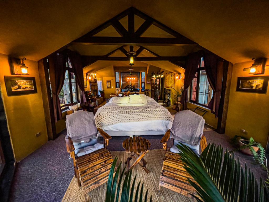 Duhatao的住宿－Homestay at "Explore Cafe & Lodge" with stunning ocean view in Chiloe Island, Patagonia，一间卧室配有一张大床和两把椅子