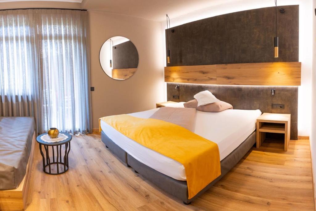 Hotel Christin في أورا / أوير: غرفة نوم بسرير كبير وأريكة