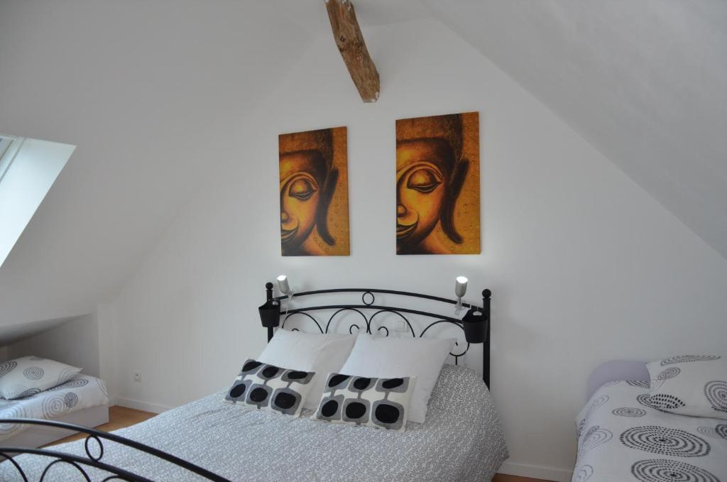 - une chambre avec un lit et 2 photos sur le mur dans l'établissement La Grange de la Gandonnerie, à Baugé