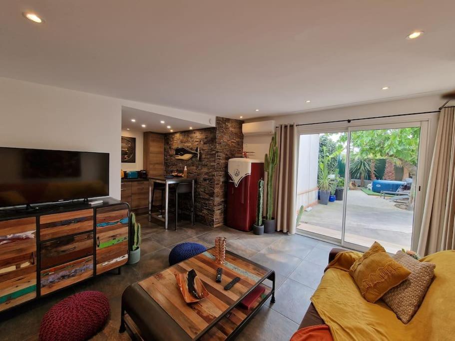 un salon avec une télévision, un canapé et une table dans l'établissement Appartement 2 Pièces proche mer calme dans villa, à Antibes