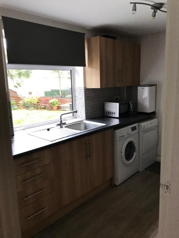 eine Küche mit einer Spüle und einer Waschmaschine in der Unterkunft 2or3 double bedrooms apartment free parking in Edinburgh