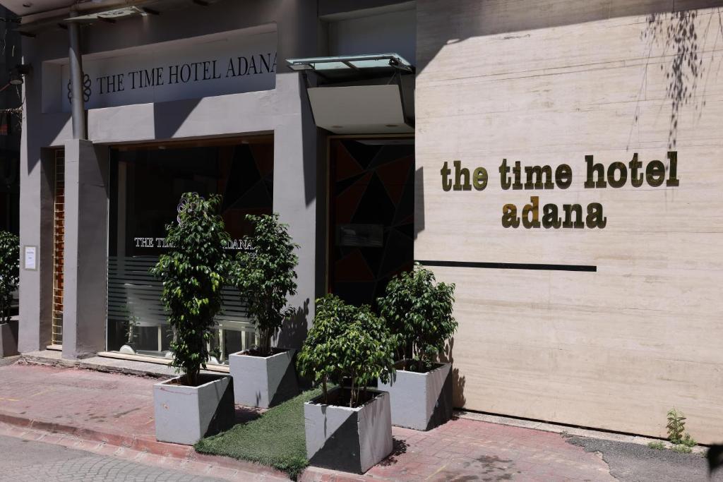 un bâtiment avec des arbres devant un hôtel dans l'établissement The Time Hotel Adana, à Seyhan