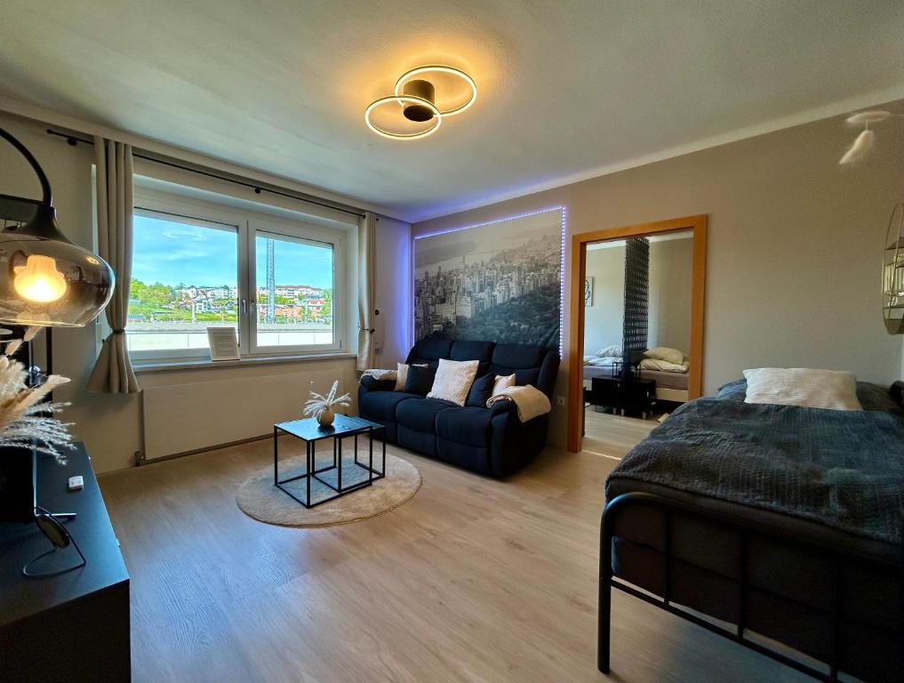 een slaapkamer met een bed en een woonkamer met een bank bij StayRoom Apartments I "U151" in Linz