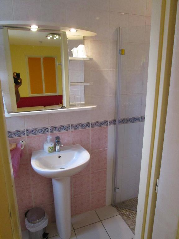 a bathroom with a sink and a shower with a mirror at Locatlantique in Aytré