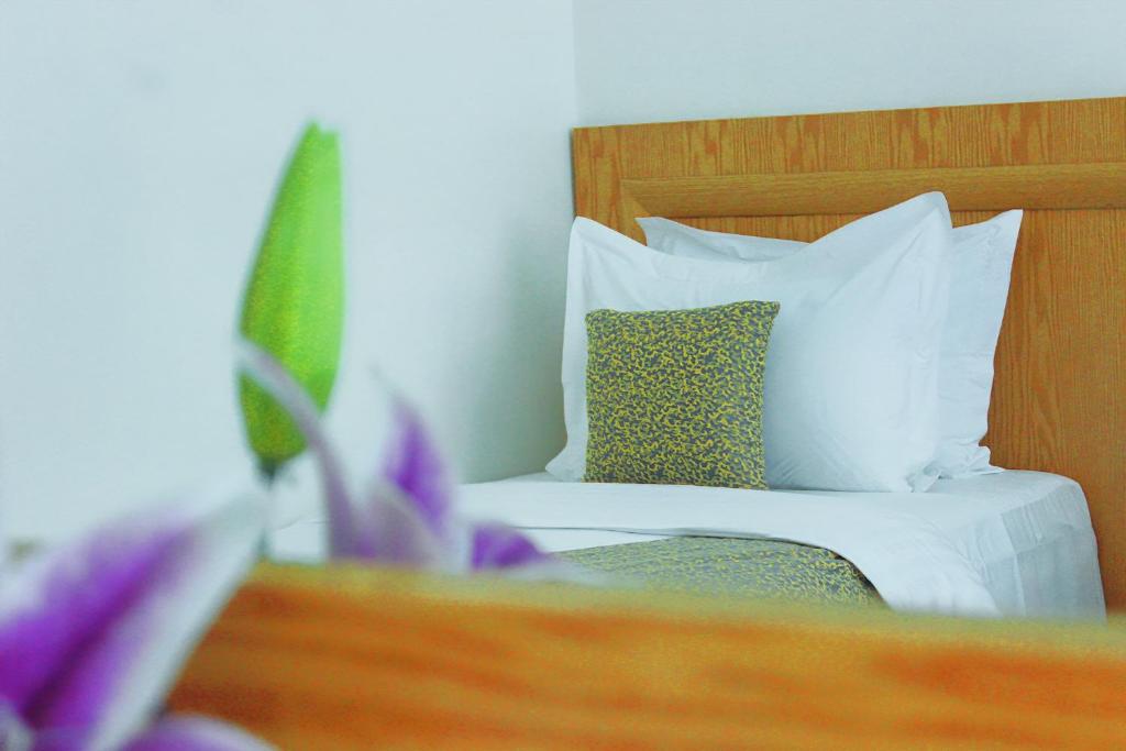 a bedroom with a bed with white sheets and pillows at Majliss Hotel Downtown in Rabat
