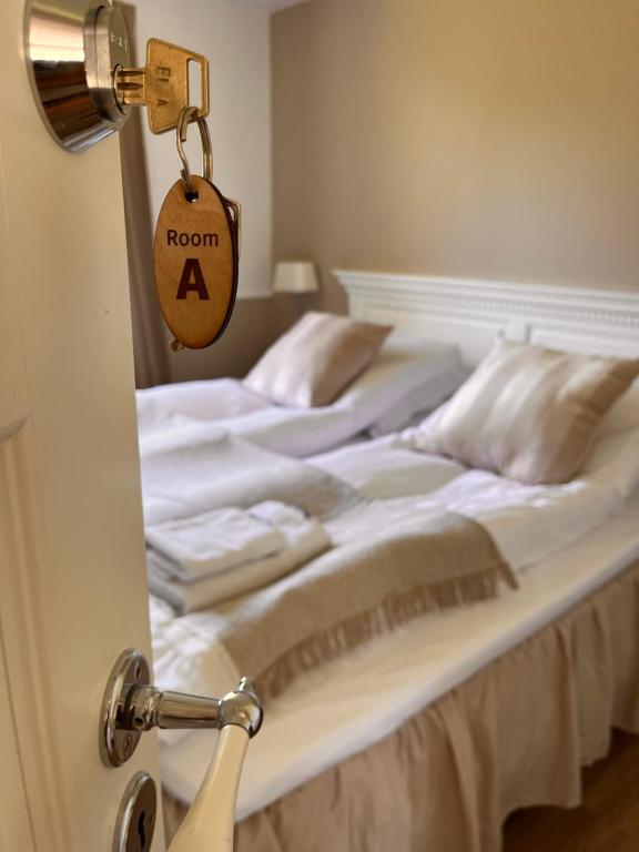 um quarto com uma cama com um quarto um sinal na porta em Munkgaard Bed & Breakfast em Rødvig
