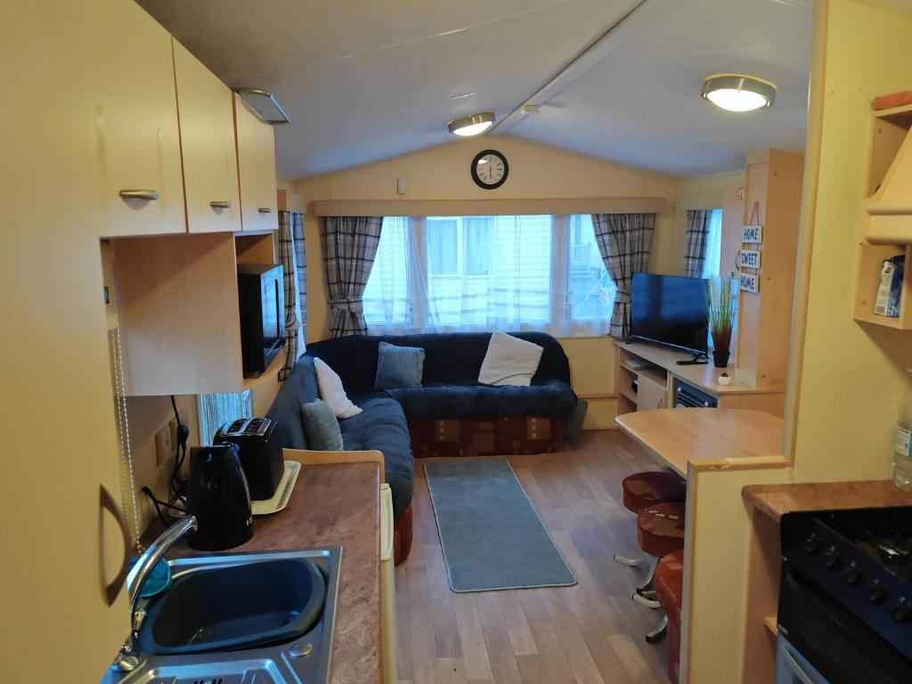 a small living room with a couch and a tv at 237 Sealands, 8 Birth caravan in Ingoldmells