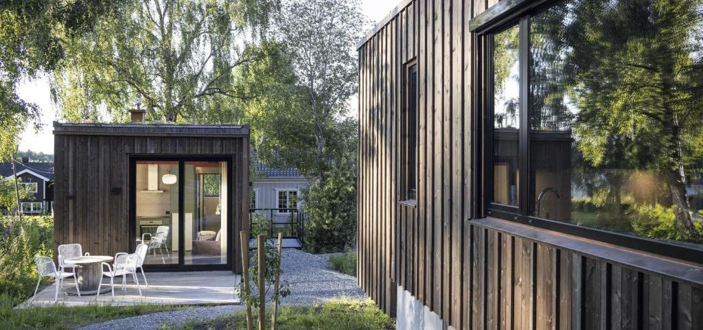 una casa in legno con una porta in vetro e un tavolo con sedie di Wergelandshaugen a Eidsvoll