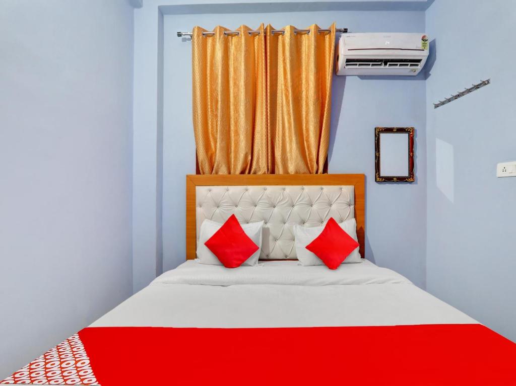 a bedroom with a bed with two red pillows at Flagship Hotel Aradhya Galaxy in Bhauli