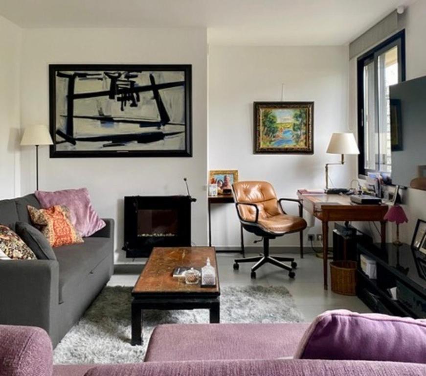 un salon avec un canapé et un bureau dans l'établissement Spontini, à Paris