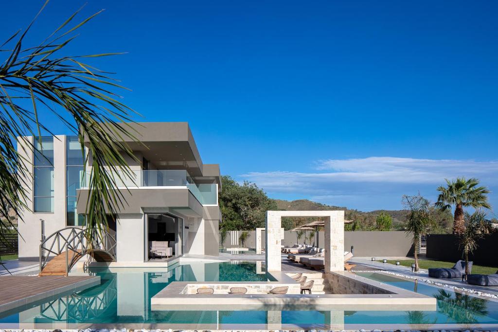 a villa with a swimming pool and a house at Elinor Villa - Nature Retreat amidst Mountains & Lake by etouri in Chania