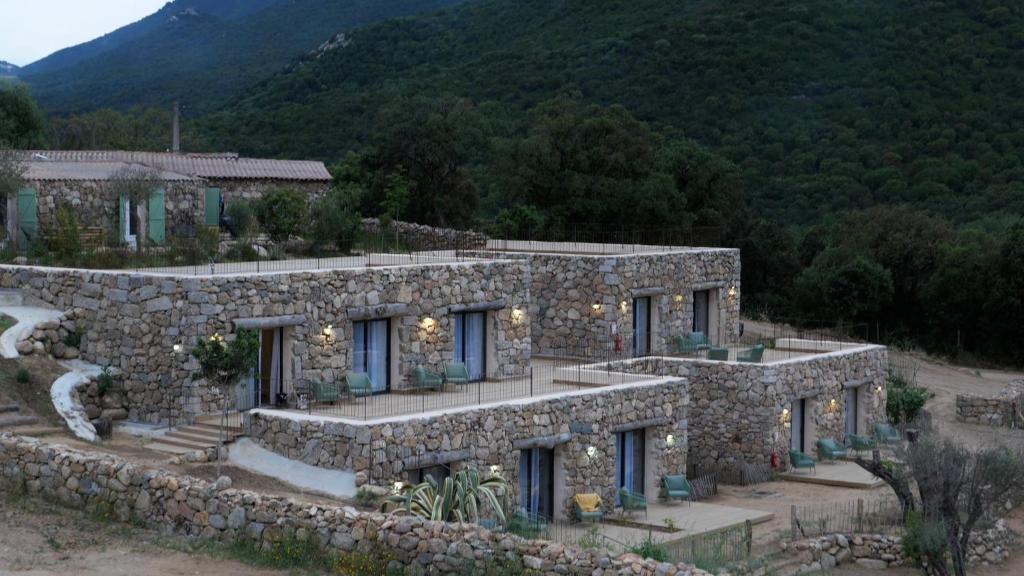 une maison en pierre avec un mur en pierre dans l'établissement A Machja, à Olmiccia