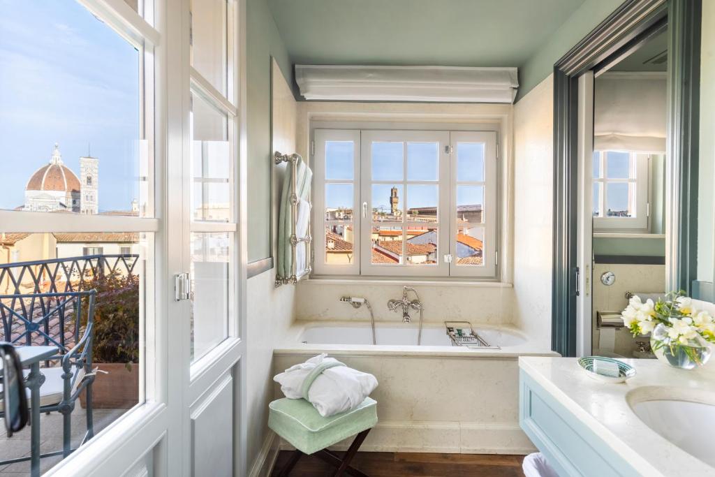 baño con bañera, lavabo y ventana en The Place Firenze, en Florencia