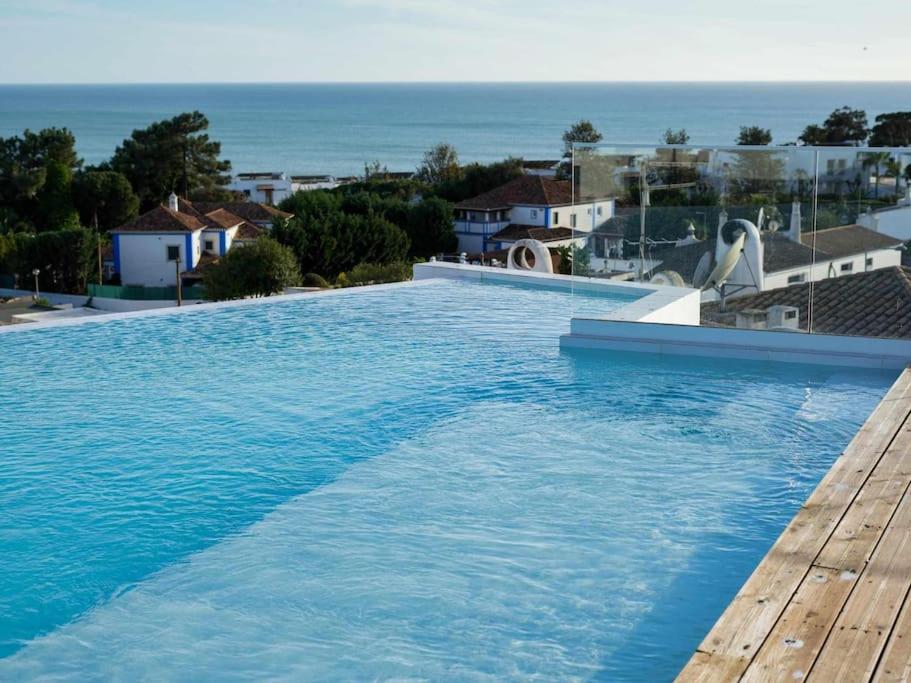 uma grande piscina com vista para o oceano em Panoramic E Apartment - Rooftop Pool & Sea View & BBQ em Albufeira