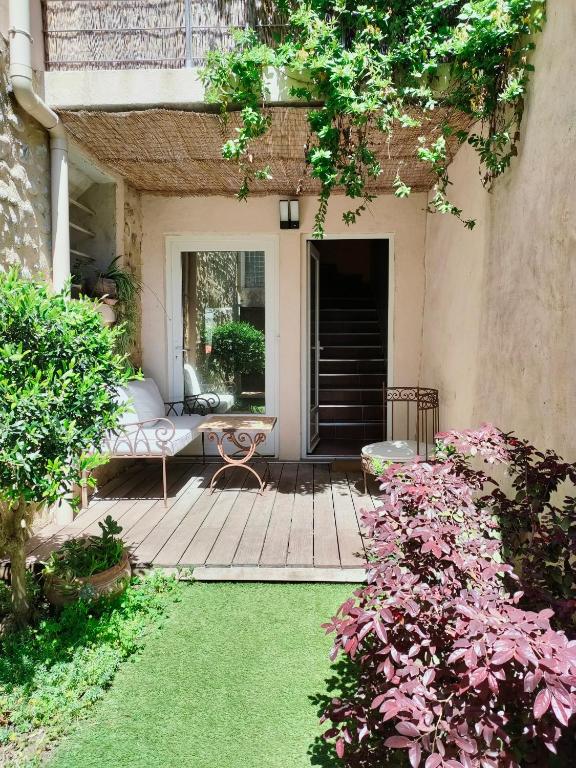 un patio avec un canapé, une table et des fleurs dans l'établissement La magnanerie colorée. (5 personnes, 3 chambres), à Ancône