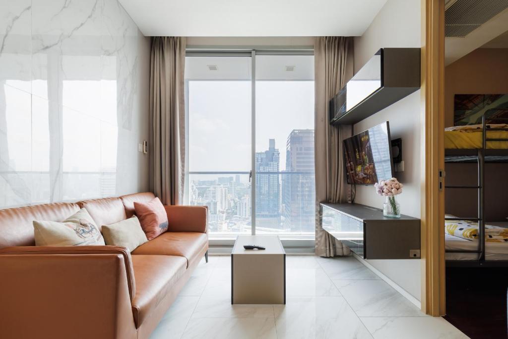 een woonkamer met een bank en een groot raam bij Modern Luxury 2 Bedrooms at BTS Nana on 30 Floor in Bangkok
