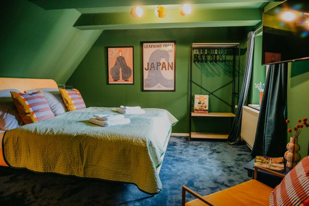 a green bedroom with a bed and a green wall at sleepArt green in Celle