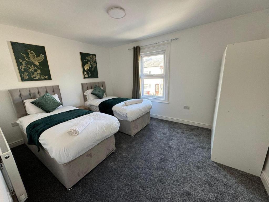a bedroom with two beds and a window at Stunning 4 BED House for Contractors & Holiday Makers in Reading