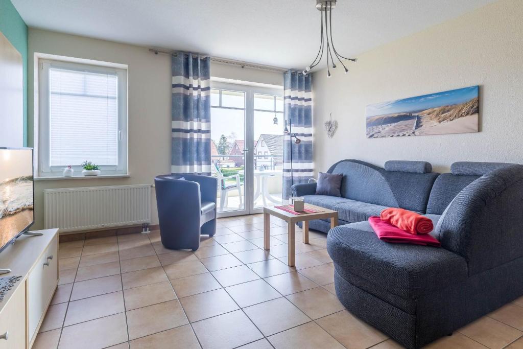 een woonkamer met een bank en een tv bij Haus Undine Wohnung 08 in Boltenhagen