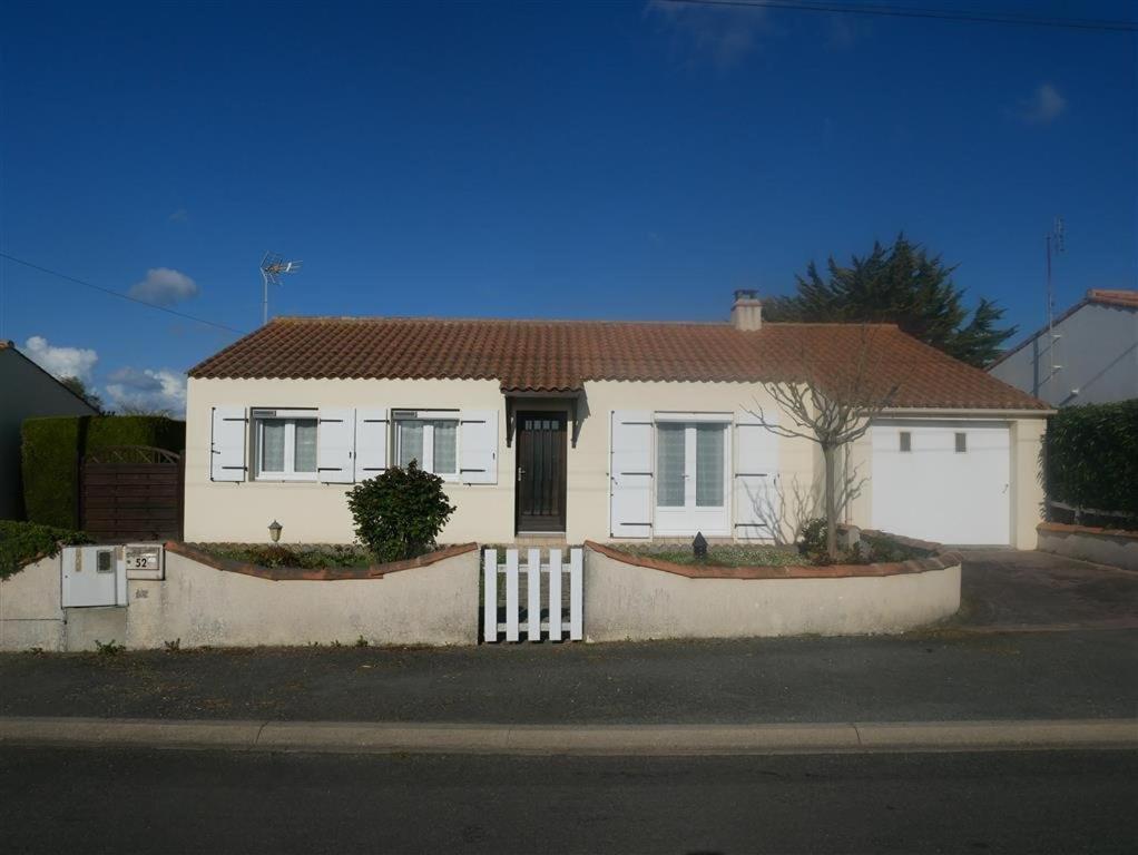 une maison blanche avec une clôture devant dans l'établissement La grande vigne de Boisvinet, à Saint-Hilaire-de-Riez