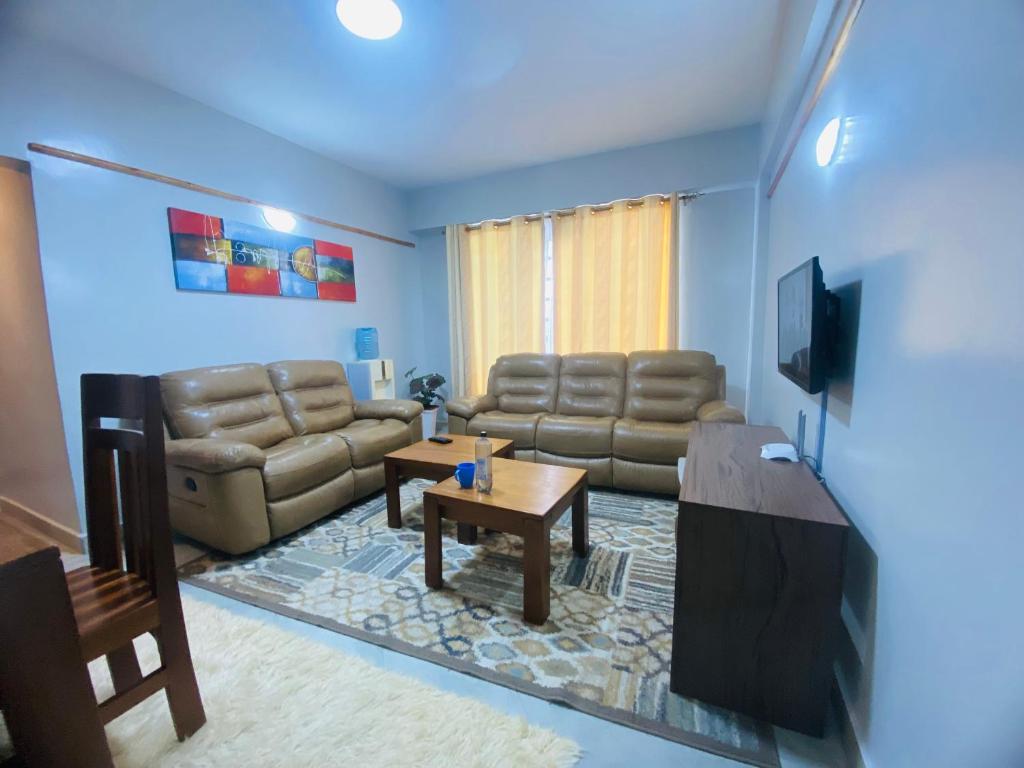 een woonkamer met een bank en een tv bij Pendeza Hyrax Residence in Nakuru