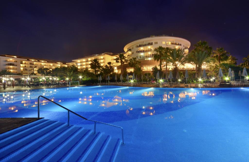 ein großer Pool vor einem Gebäude in der Nacht in der Unterkunft Seaden Sea World Resort & Spa All Inclusive in Kizilagac
