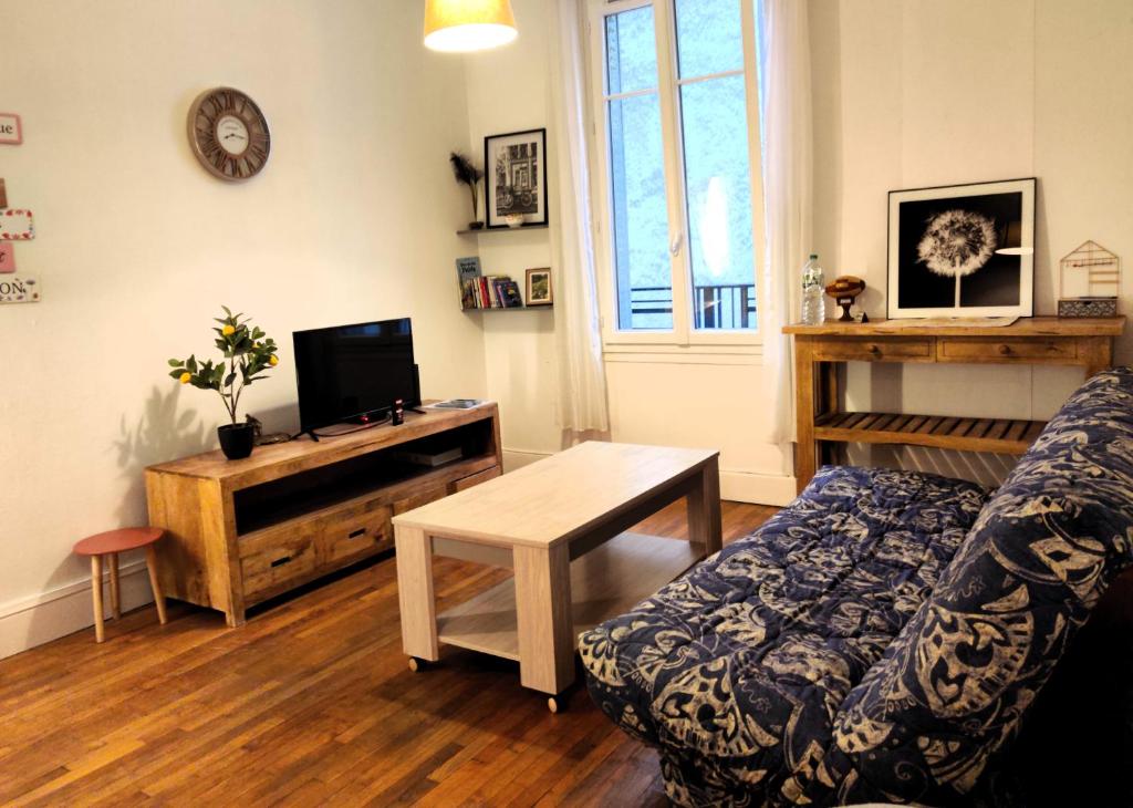 uma sala de estar com um sofá e uma mesa em Au Cœur de Troyes - Calme et Confort em Troyes