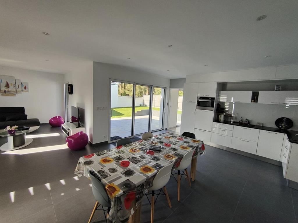 Il comprend un grand salon avec une table et une cuisine. dans l'établissement La moderna de la Pège, à Saint-Hilaire-de-Riez