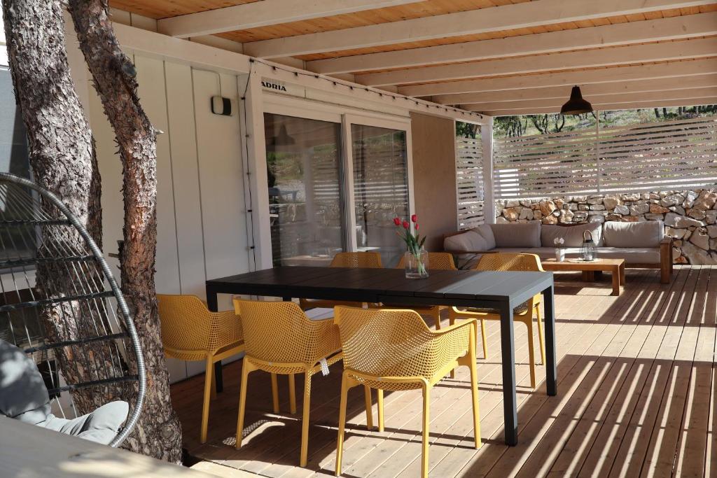 un patio con mesa y sillas en una terraza en Mobilna kućica Val en Šimuni