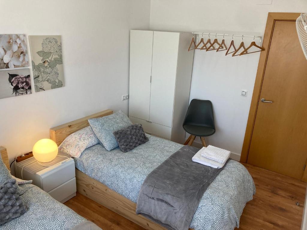 1 dormitorio con 1 cama y 1 silla en Roshi's Home, en Sant Jaume d'Enveja