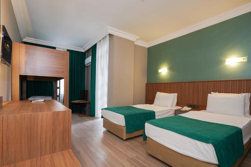 a hotel room with two beds and a television at ERGÜN OTEL in Alanya