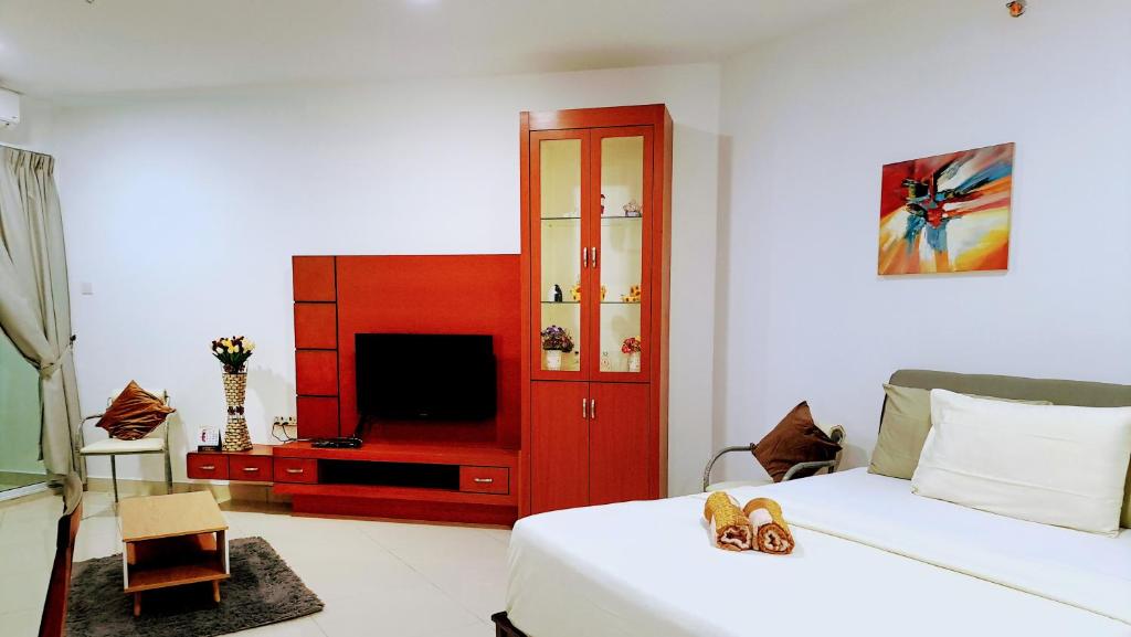 um quarto com uma cama, uma televisão e um armário vermelho em Mansion One - Large Studio with 1 bathroom em George Town