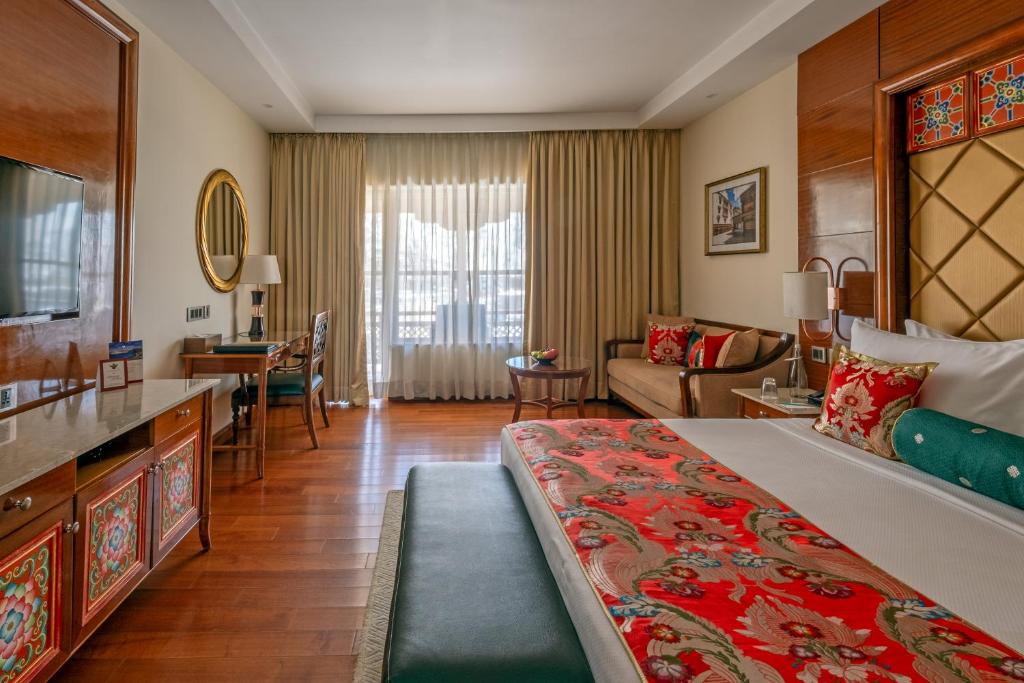 a hotel room with a large bed and a living room at The Grand Dragon Ladakh in Leh