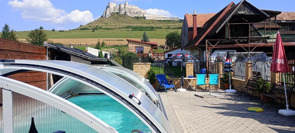 a house with a swimming pool with a mountain in the background at A+S Penzion Podzamok in Spišské Podhradie