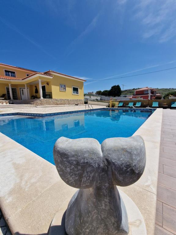 a statue in front of a swimming pool at Porto Dinheiro Beach II in Casal do Cigano