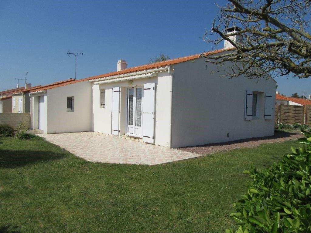 une maison blanche avec une cour d'herbe dans l'établissement L'Oberlin de la ville, à Saint-Hilaire-de-Riez